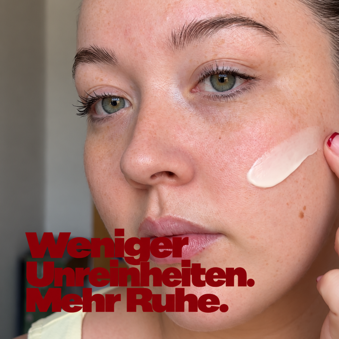 Frau mit einem Cremestreifen auf der Wange, dazu die Zeile 'Weniger Unreinheiten. Mehr Ruhe.'